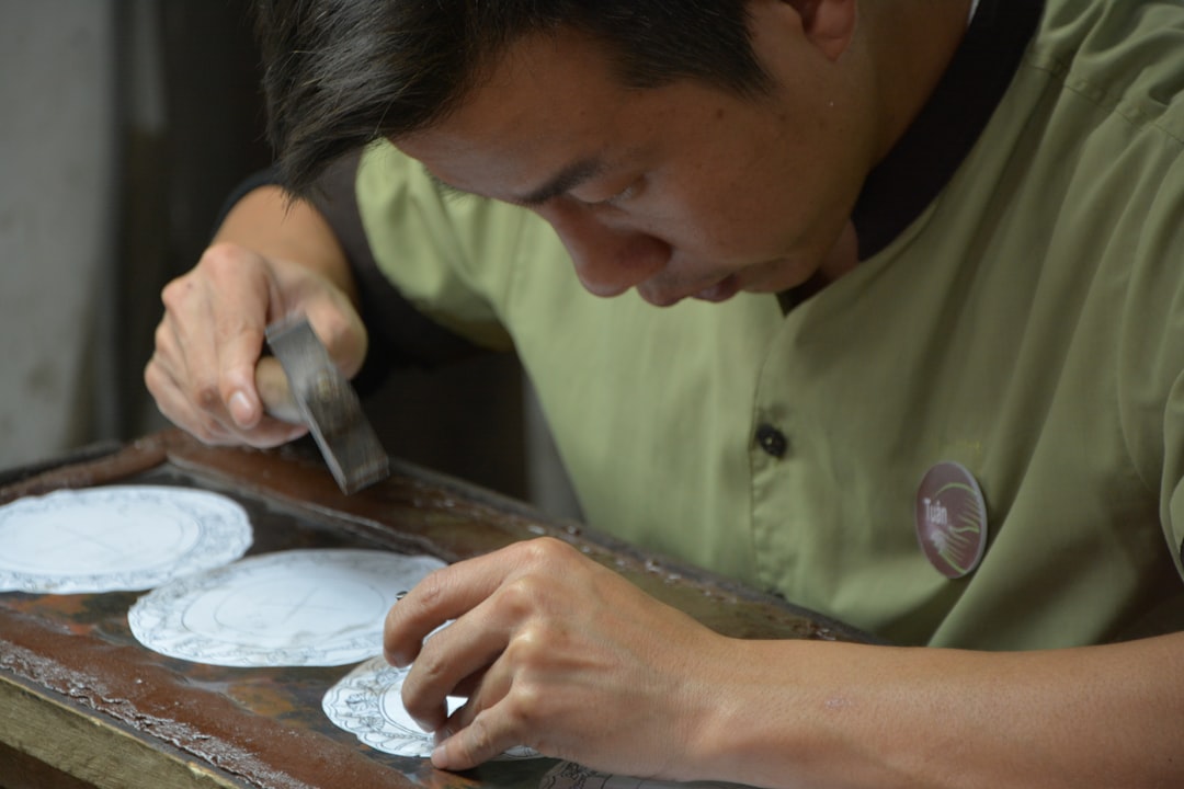Thợ thủ công gõ thiết kế bằng búa và dụng cụ nhọn