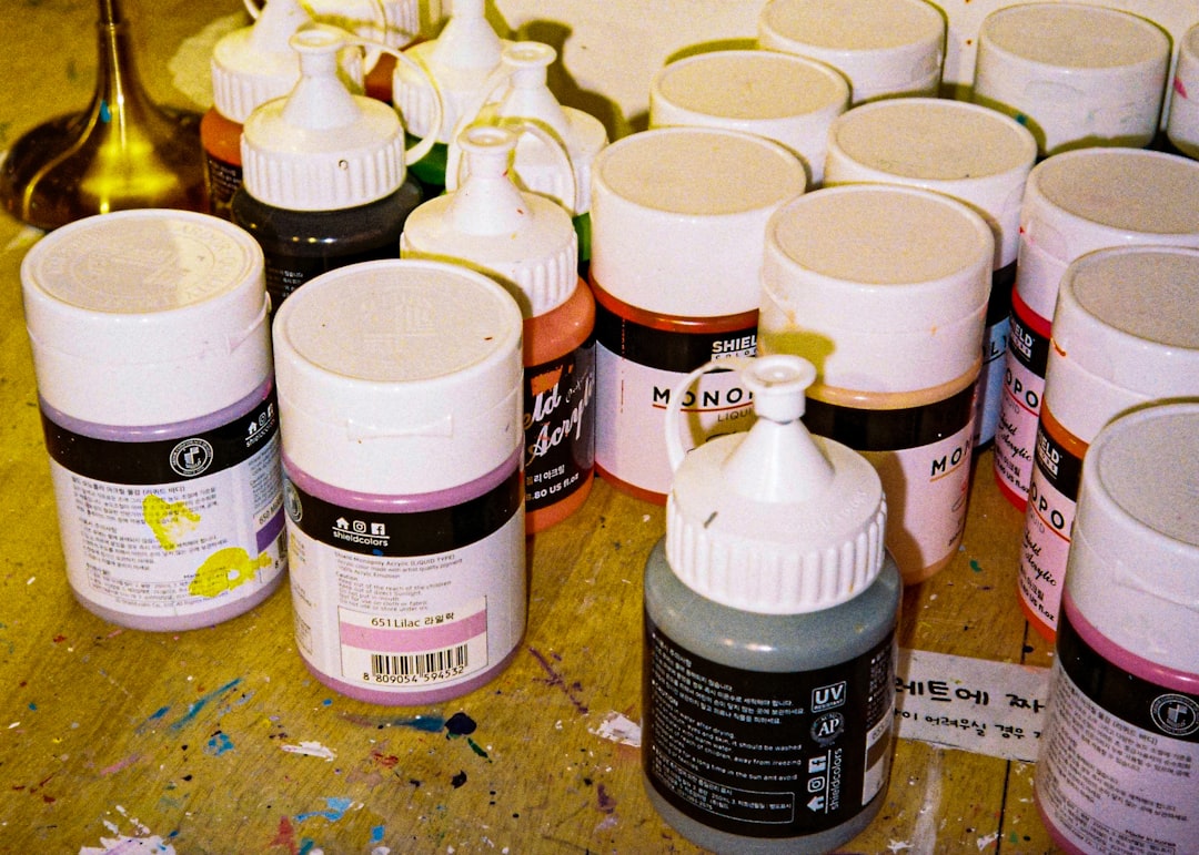 a table topped with lots of bottles of paint