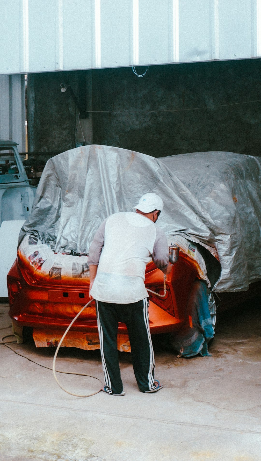 Người thợ làm việc với máy chà nhám trên xe